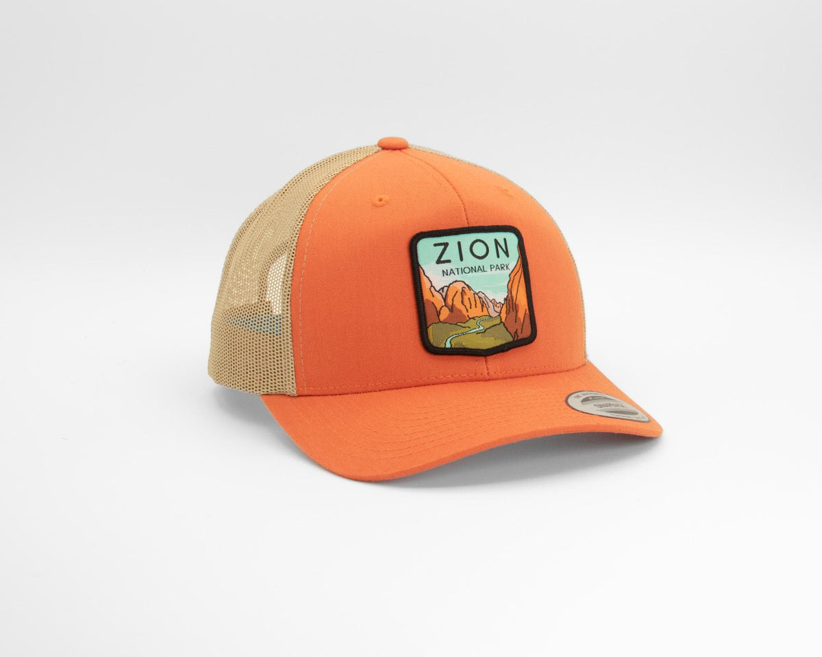 Bright orange Zion National Park trucker hat photographed close, patch centered and brim tipped forward.