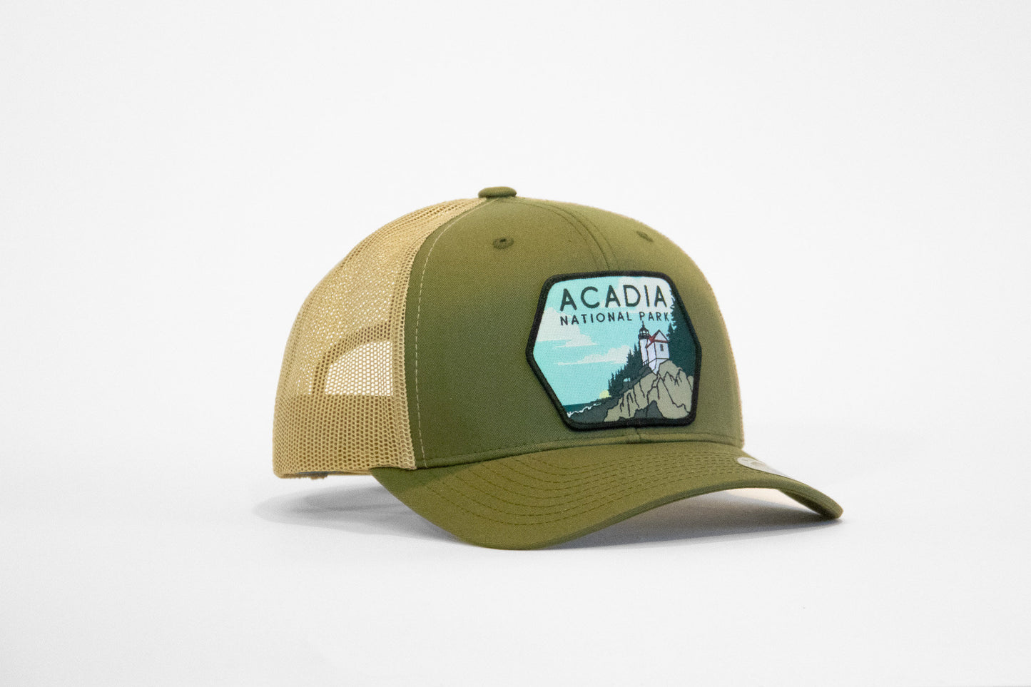 Front three quarter view of the green Acadia National Park trucker hat, brim curved and patch stitched flat.