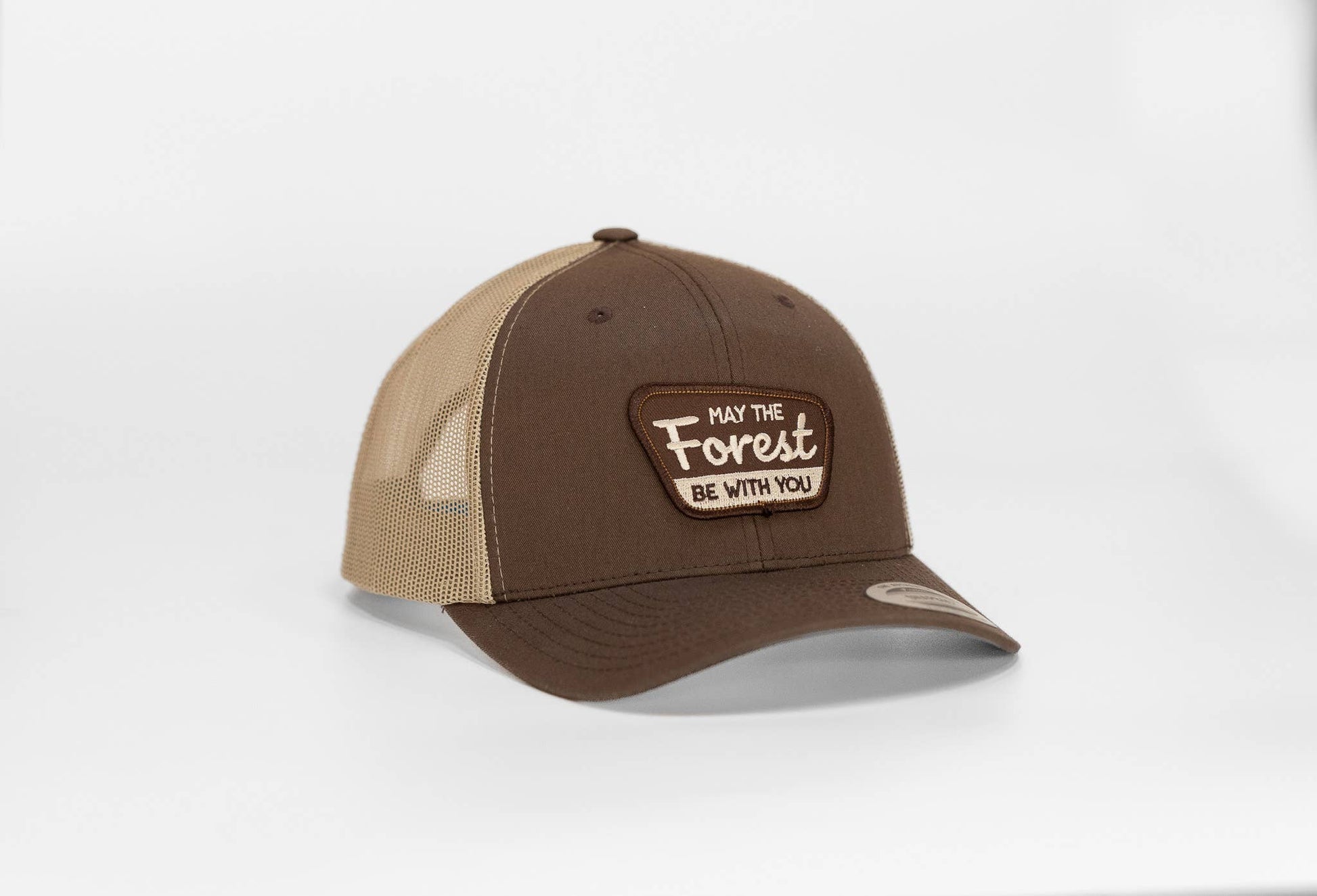Brown crown and tan mesh on the May The Forest Be With You trucker hat, patch lettering in cream on white.