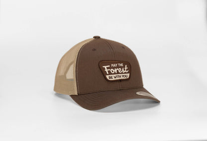 Brown crown and tan mesh on the May The Forest Be With You trucker hat, patch lettering in cream on white.