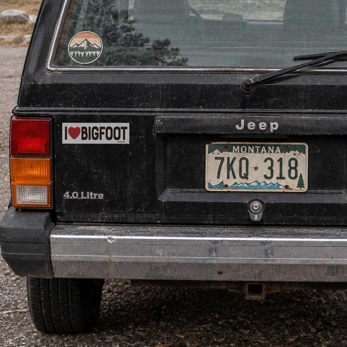 A black Jeep Cherokee displays the I Heart Bigfoot sticker near its taillight above a Montana plate.