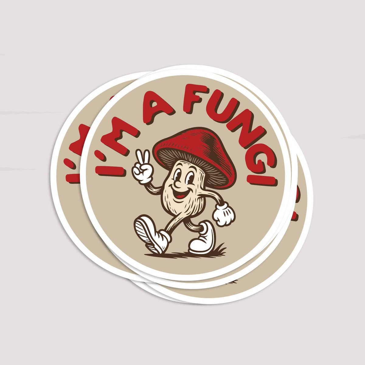 Three copies of the I'm a Fungi sticker stacked and fanned on a pale grey surface.