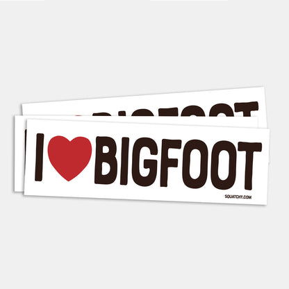 Two I Heart Bigfoot bumper stickers lie stacked on a grey surface, the red heart standing out against bold black letters.