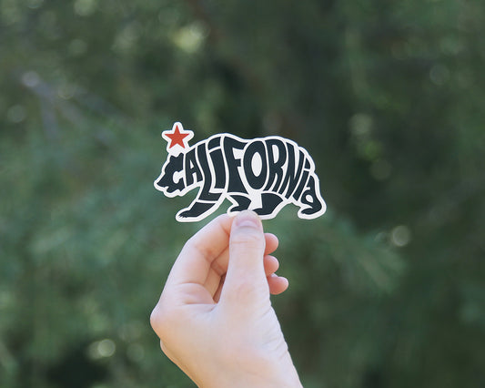 Framed wider against the same trees, the California Republic Grizzly sticker shows its red star and bear shape.