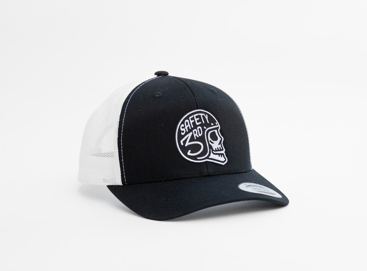 Black crown and white mesh meet on the Safety 3rd Helmet trucker hat, patch centered above the curved brim.