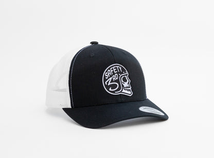 Black crown and white mesh meet on the Safety 3rd Helmet trucker hat, patch centered above the curved brim.