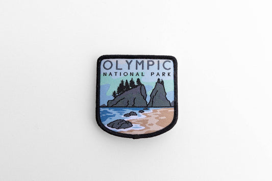 Laid flat on white, the Olympic National Park patch shows sea stacks, surf and sand inside a black border.