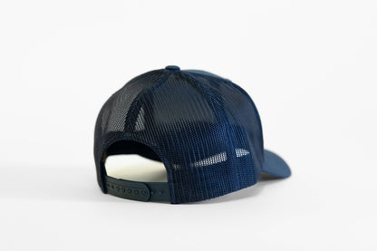 From behind, the navy Olympic National Park trucker hat shows dark mesh panels and an open snap closure.