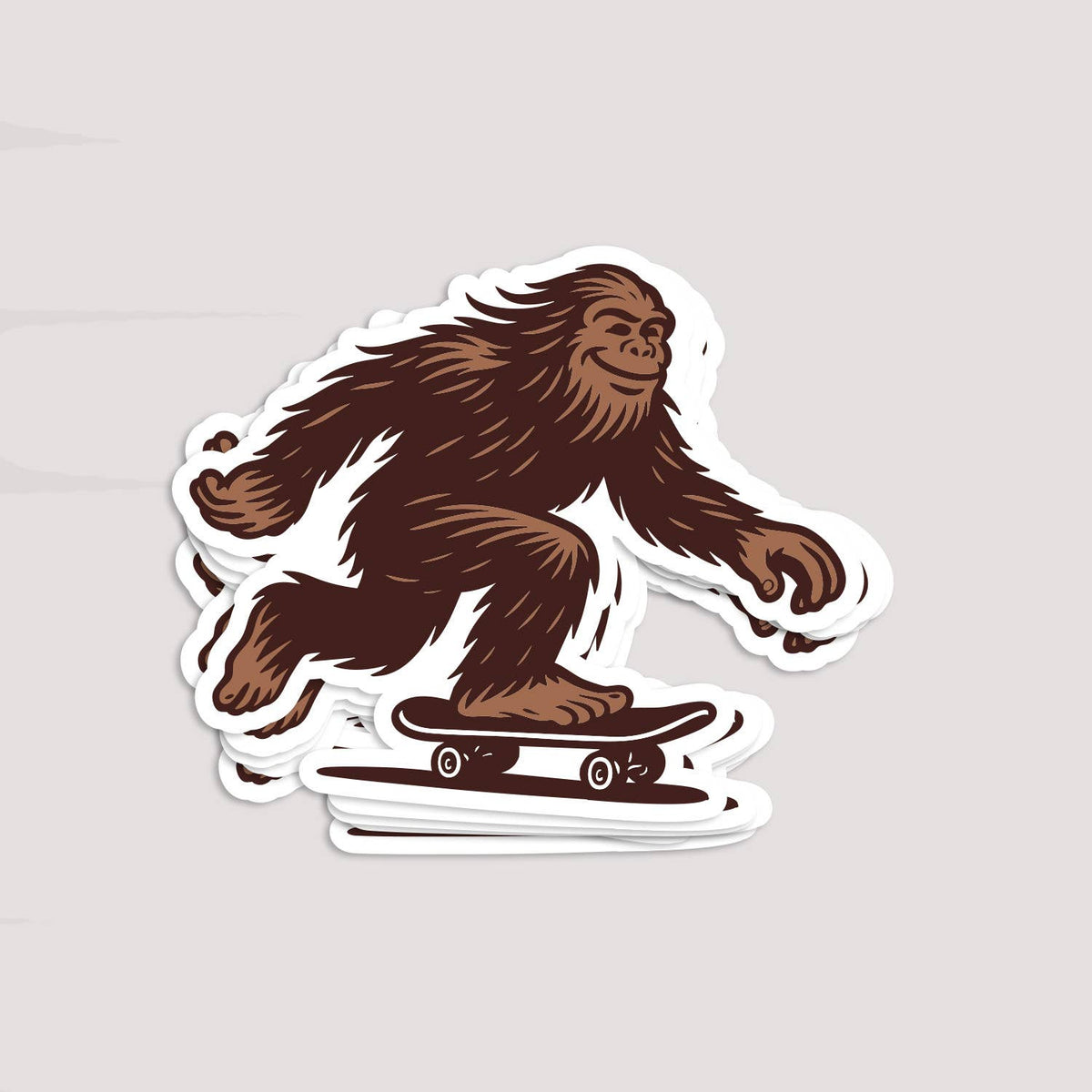 A stacked pile of Later Skater Bigfoot stickers sits on a light grey surface, edges fanned out.