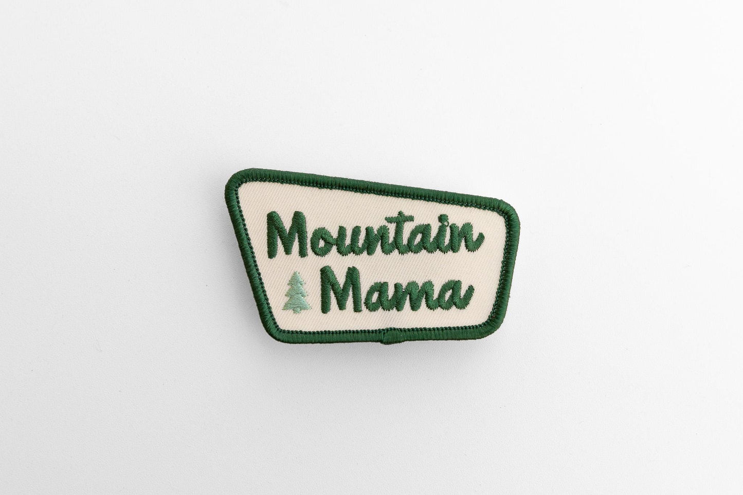 Laid flat and seen small on white, the Mountain Mama patch keeps its angled shape and cream center.