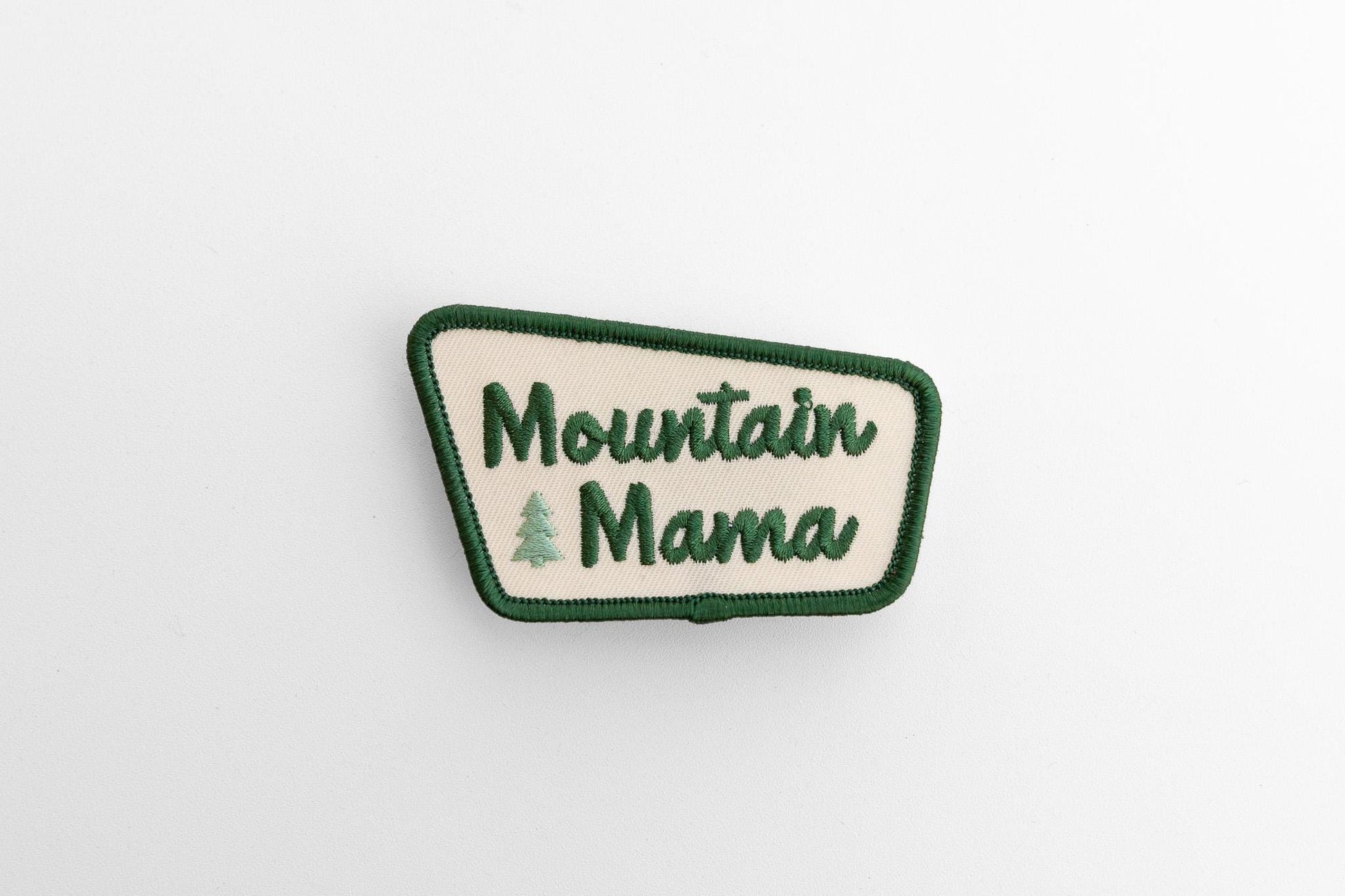 Laid flat and seen small on white, the Mountain Mama patch keeps its angled shape and cream center.