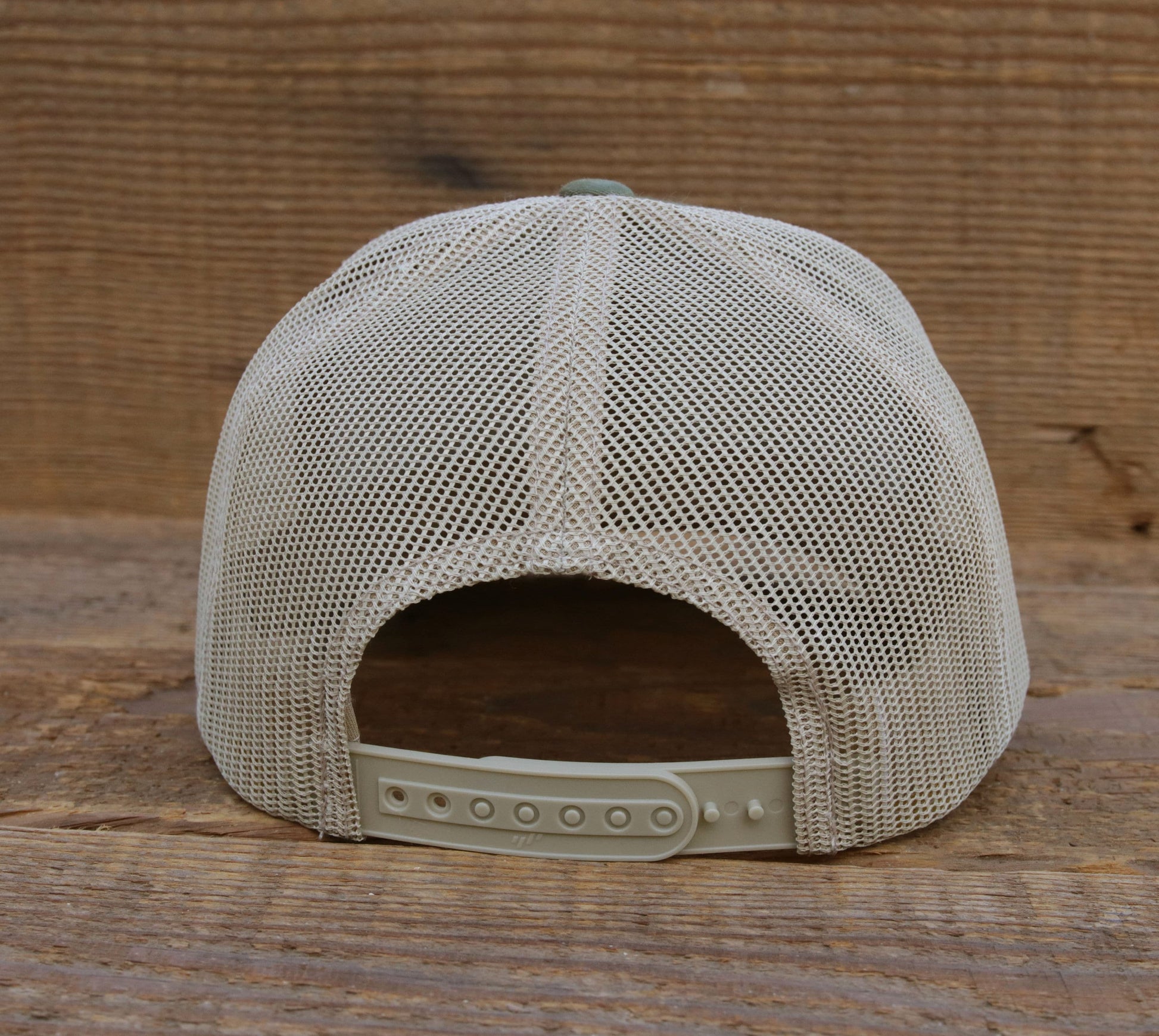 Rear of the Appalachian Trail trucker hat against barnwood, cream mesh above the row of snap holes.