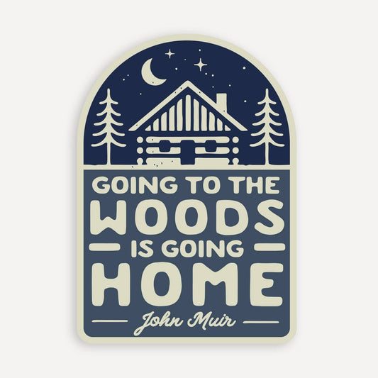 Arched navy Going to the Woods is Going Home sticker with a log cabin, moon and stars above the John Muir quote.