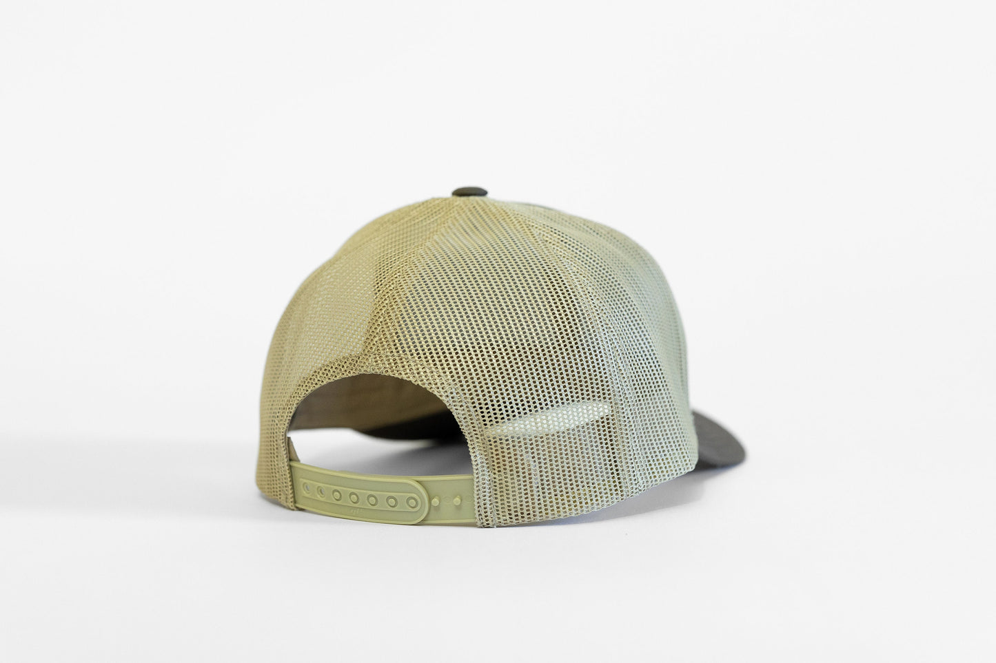 Khaki mesh and a pale green snap strap close the back of the olive Out of Breath Hiking Society trucker hat.