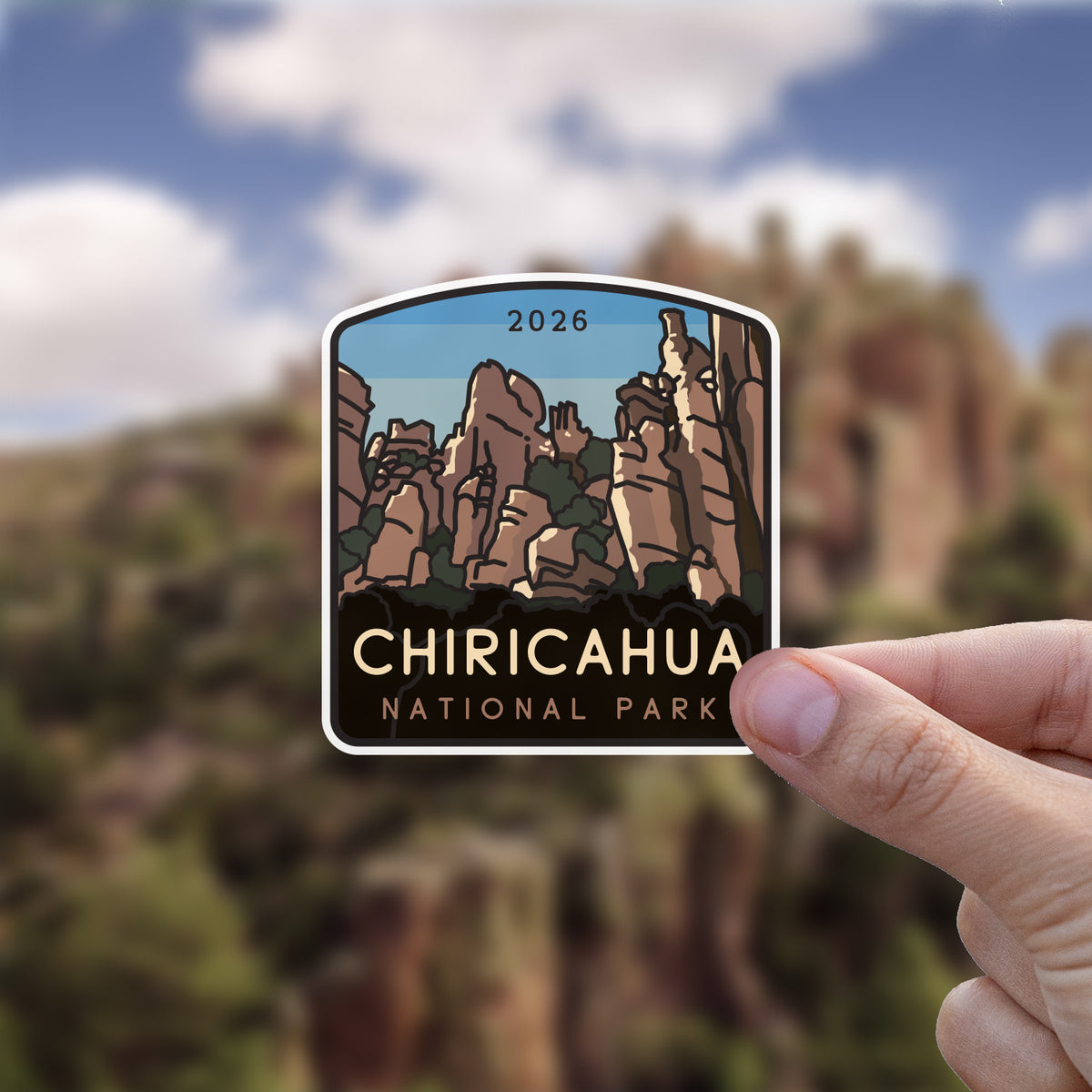 Held up against a blurred canyon landscape, the Chiricahua National Park sticker shows its own rock formations in miniature.