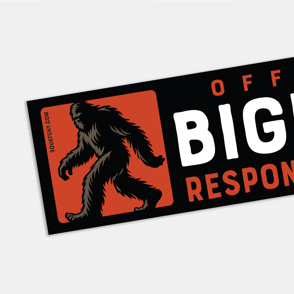 Angled close up, the sticker's edge cuts off the text while the orange sasquatch panel stays fully in view.