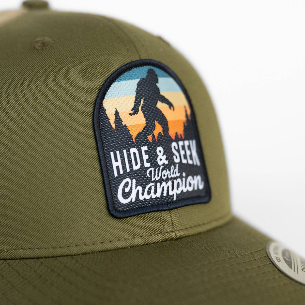 Stitched to olive canvas, the Hide and Seek World Champion patch fills the frame with its Bigfoot silhouette.