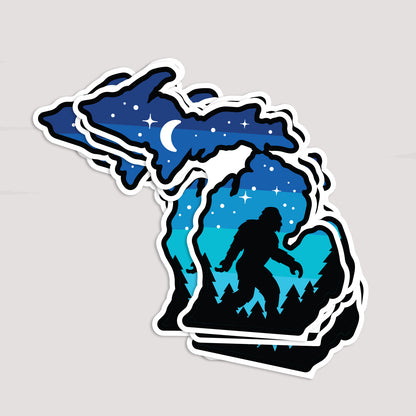 Several Michigan Sasquatch stickers are stacked together, fanning out to show repeated copies of the same design.