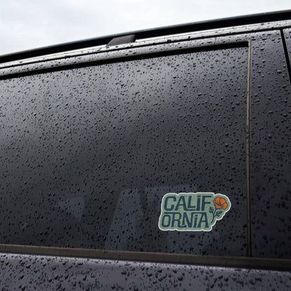 Rain beads across a black car window where the California Poppy sticker is applied near the door frame.