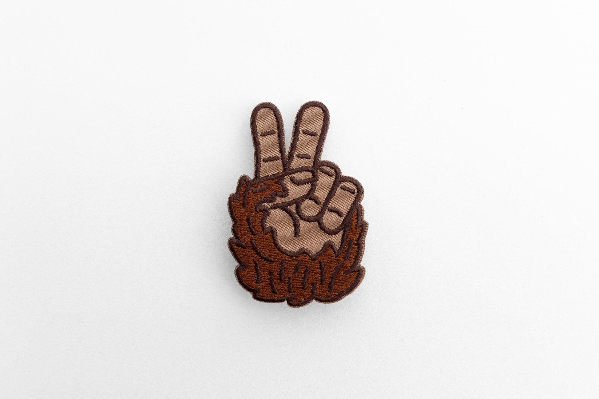 Set small and centered on a white surface, the Bigfoot Peace Patch casts a faint shadow.