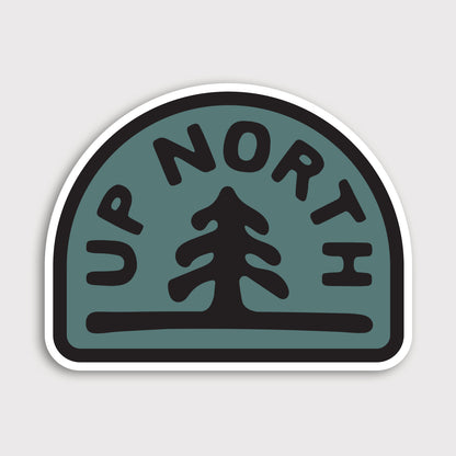 The Up North sticker shows a single pine tree and arched lettering in black on a teal badge shape.