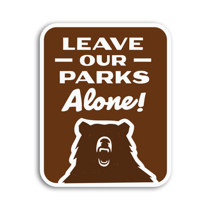 A brown Leave Our Parks Alone sticker shows a roaring bear beneath bold white lettering on a plain background.