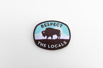 Set small in the frame on a plain white surface, the Respect The Locals bison patch sits slightly angled.