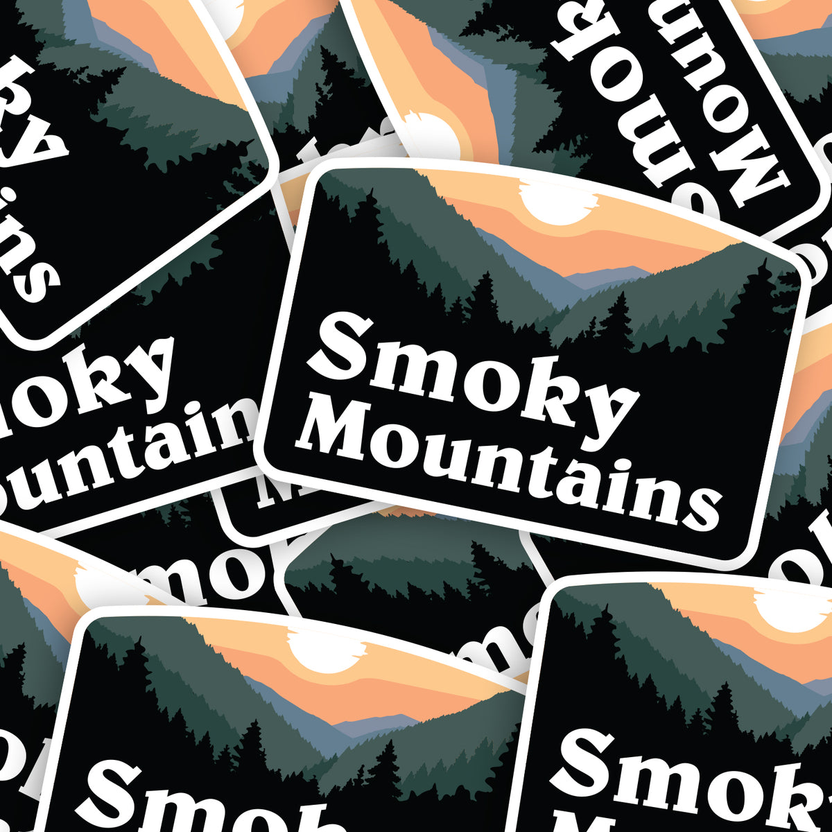 A pile of Smoky Mountains stickers overlaps at different angles, repeating the sunset ridge design.