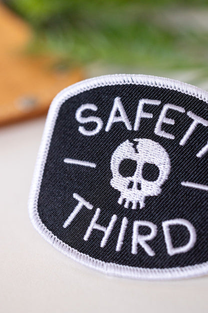 An angled close view crops the lettering of the Safety Third patch, showing raised white thread and edge stitch.