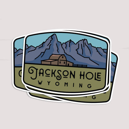 Two Jackson Hole Wyoming stickers overlap in a loose stack, the top one covering most of the one beneath.
