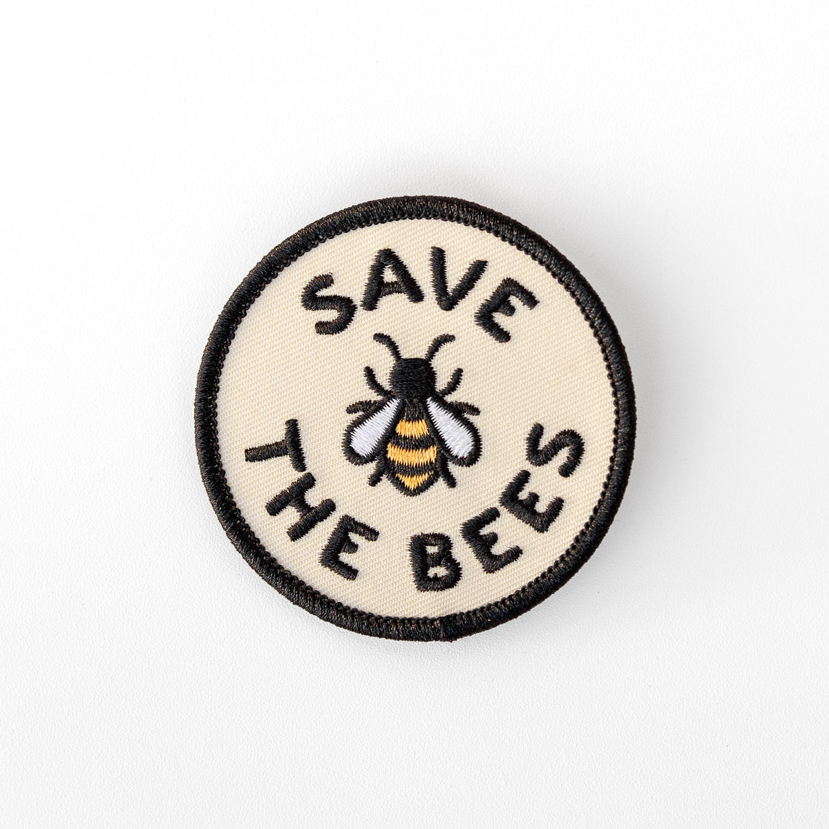 Centered on a plain white background, the Save The Bees patch shows its embroidered bee in gold, white and black.