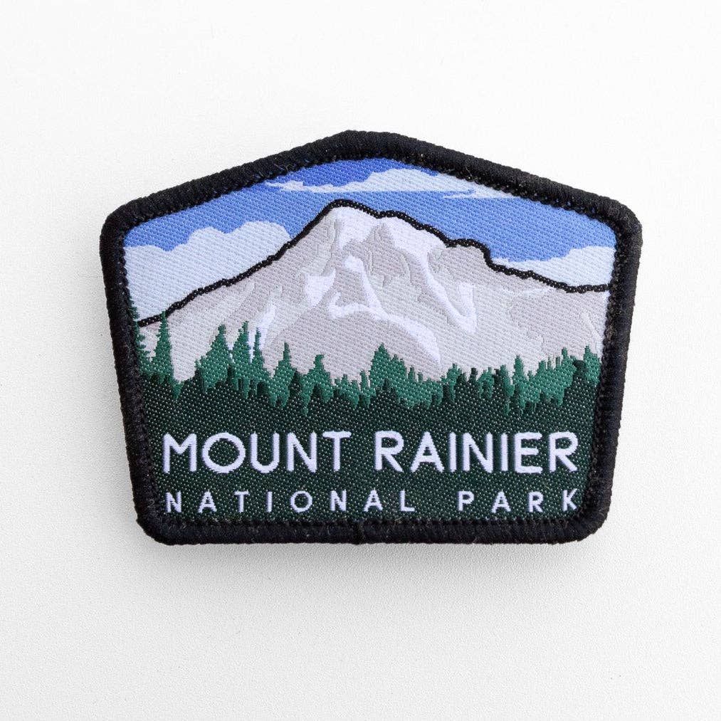 Flat on white, the Mount Rainier National Park patch shows its snowy peak, treeline and black merrowed border.