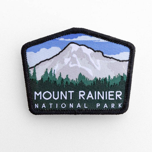 Flat on white, the Mount Rainier National Park patch shows its snowy peak, treeline and black merrowed border.