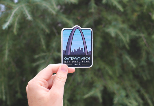 Held further back in soft daylight, the Gateway Arch National Park sticker shows its arch and city skyline.