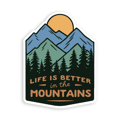Blue peaks, pine trees and an orange sun fill the Life Is Better In The Mountains sticker on white.