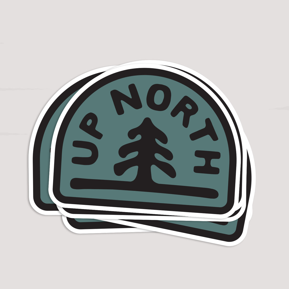 Two Up North stickers overlap in a small stack, their white borders slightly offset.