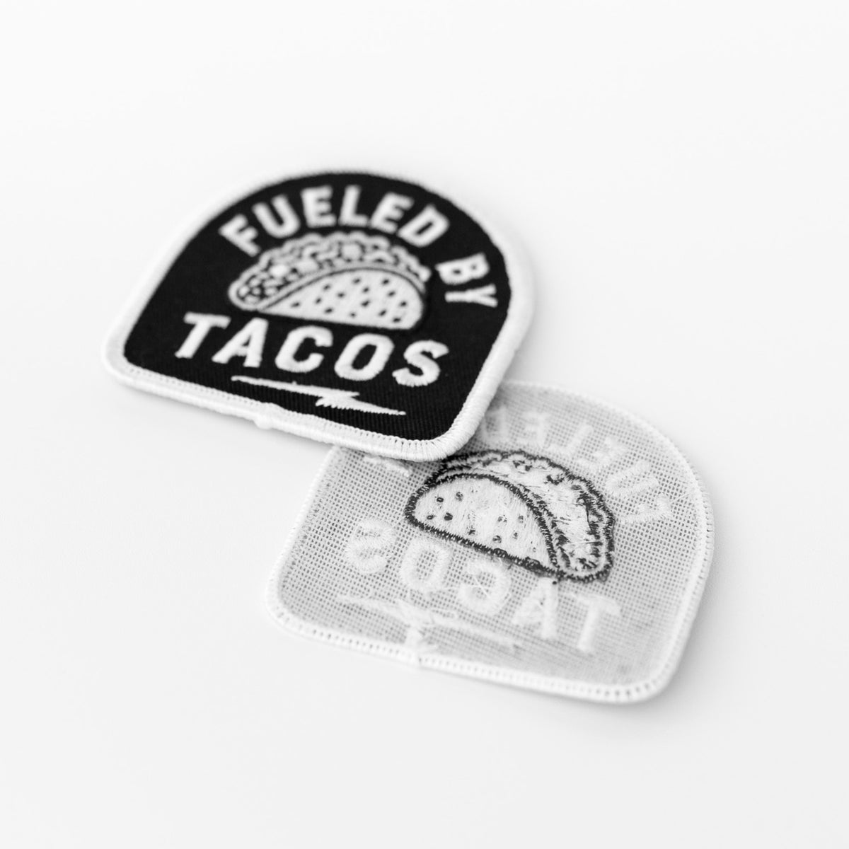 Laid front to back, the Fueled By Tacos patch and its mirrored underside show the thread lines from behind.