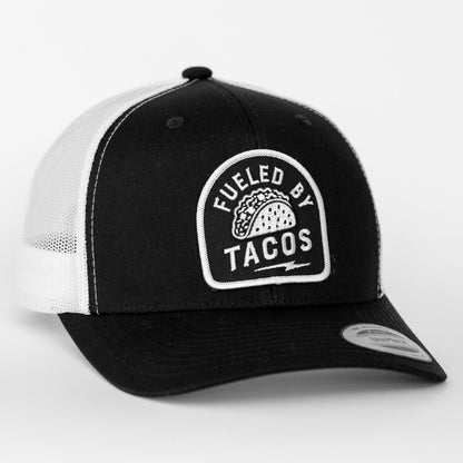 Black twill and white mesh split this Fueled By Tacos trucker hat, the taco patch sitting just above the brim.