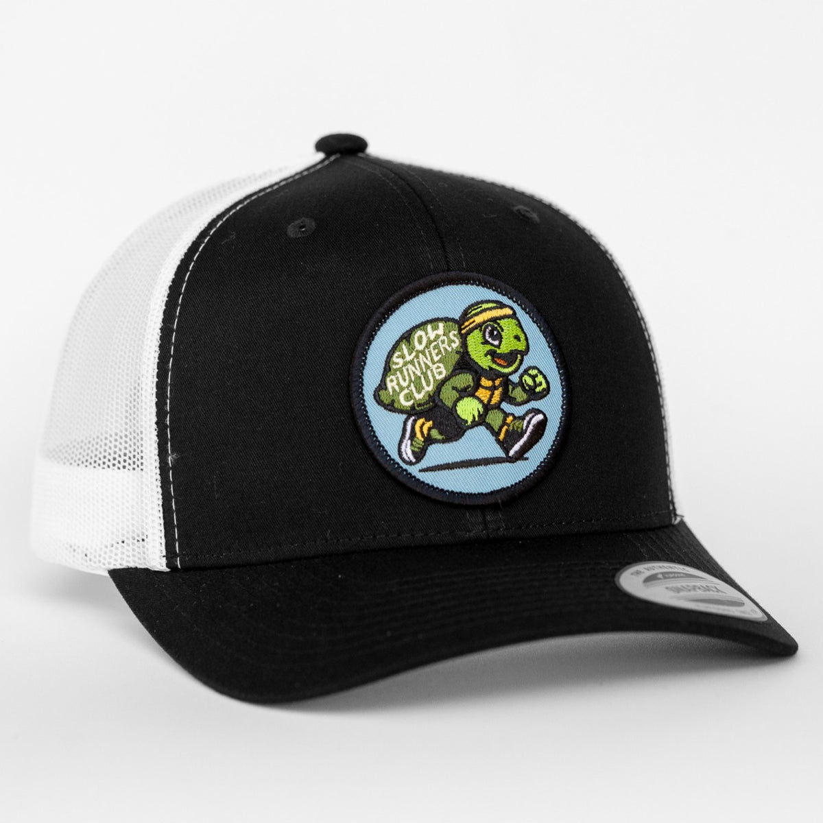 A black and white Slow Runners Club trucker hat turns slightly, showing the turtle patch against mesh siding.