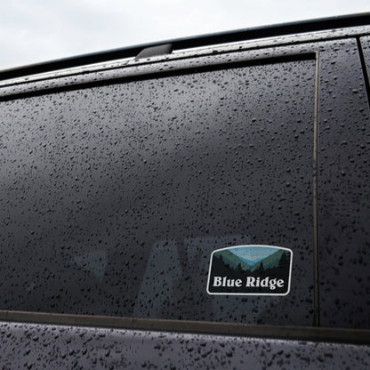 A rain streaked car window shows the Blue Ridge sticker fixed near the lower corner of the glass.