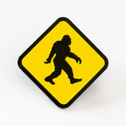 Turned on point, the diamond shaped Bigfoot Crossing pin shows its black bordered silhouette against white.