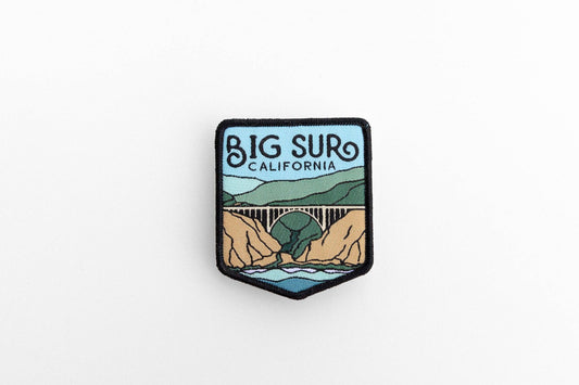 Set on a plain white background, the Big Sur California woven patch shows a bridge over a rocky cove.