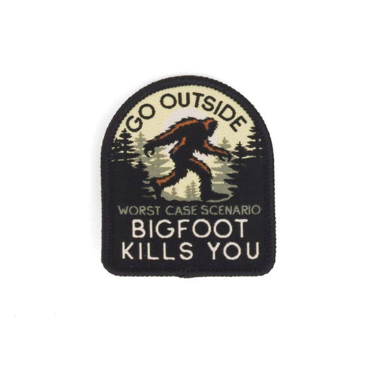 The Go Outside Worst Case Scenario Bigfoot Kills You patch sits flat on white, Sasquatch striding past dark pines.