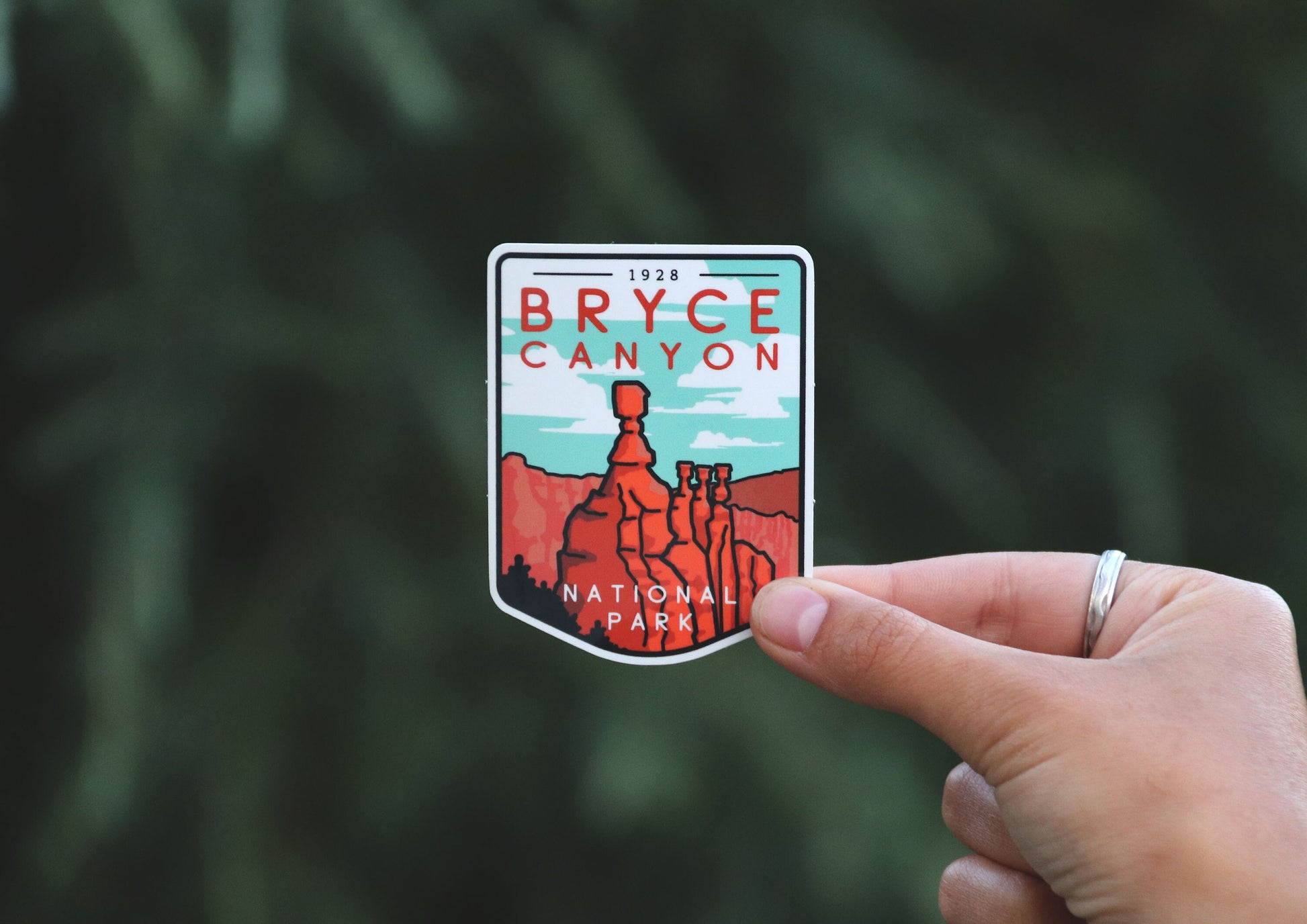 Wider framing puts the Bryce Canyon National Park sticker off to the right, hoodoos facing a soft evergreen backdrop.