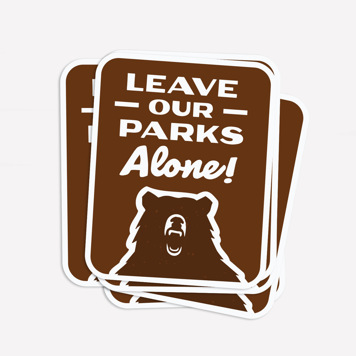 Three Leave Our Parks Alone stickers fan out slightly, stacked on top of each other.
