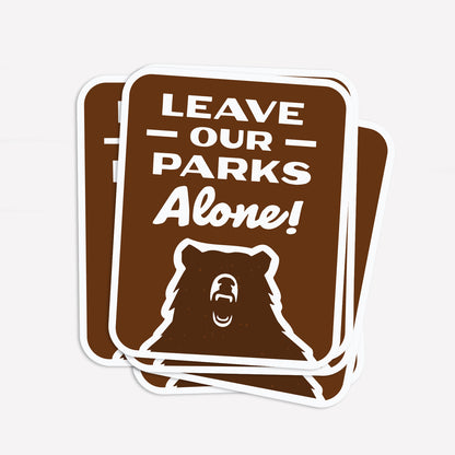 Three Leave Our Parks Alone stickers fan out slightly, stacked on top of each other.