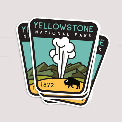Three copies of the Yellowstone National Park sticker fan out in a stack on a pale grey surface.