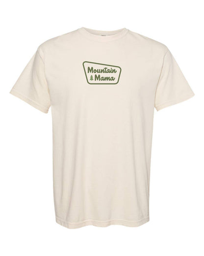 The ivory Mountain Mama T shirt lies flat on white, green badge logo centered on the chest.