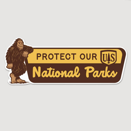 Bigfoot leans on a brown and gold park sign in the Protect Our National Parks bumper sticker on plain grey.