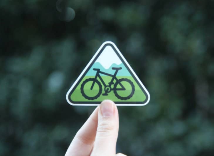 Held low in the frame, the green triangle mountain bike sticker shows snowy peaks above a fat tire bike.